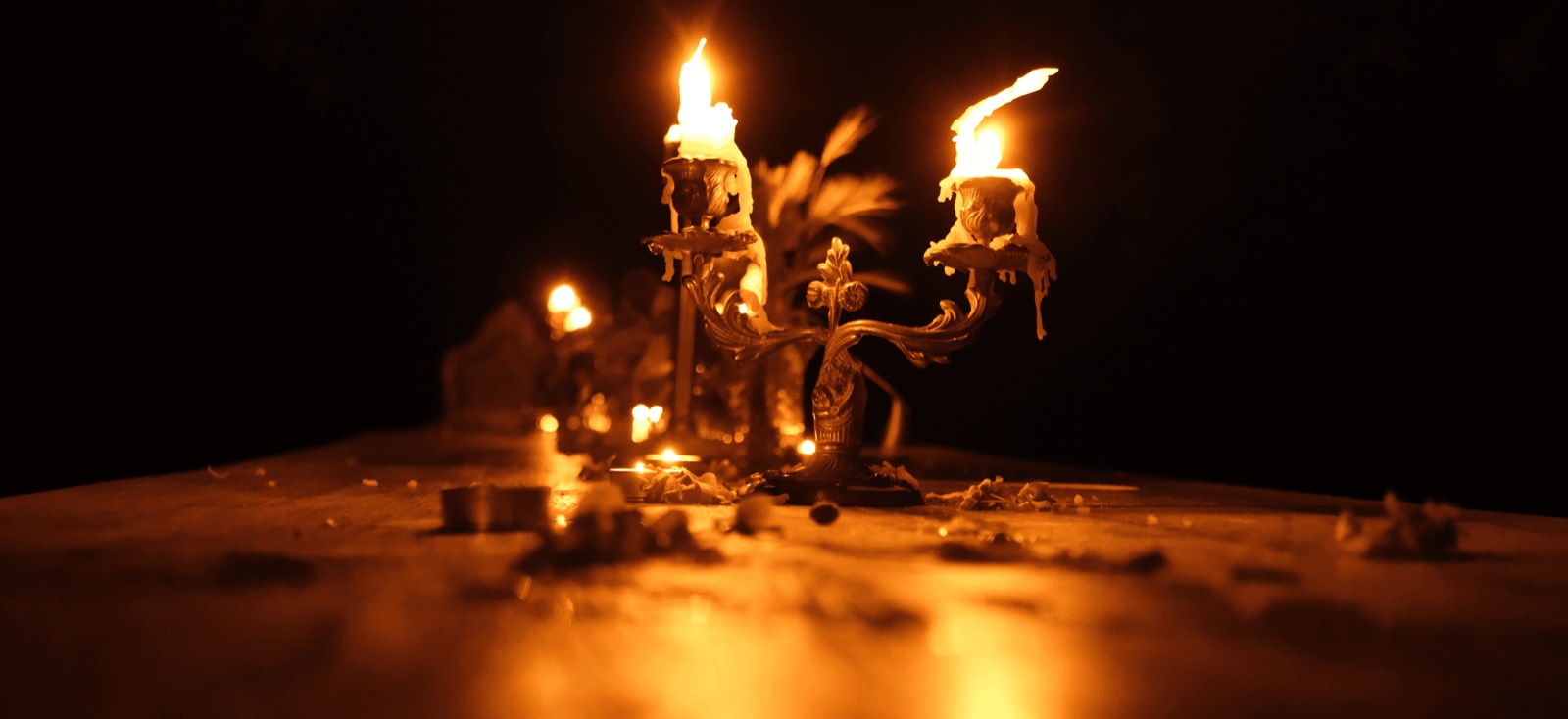 candles burning on a wooden table at night