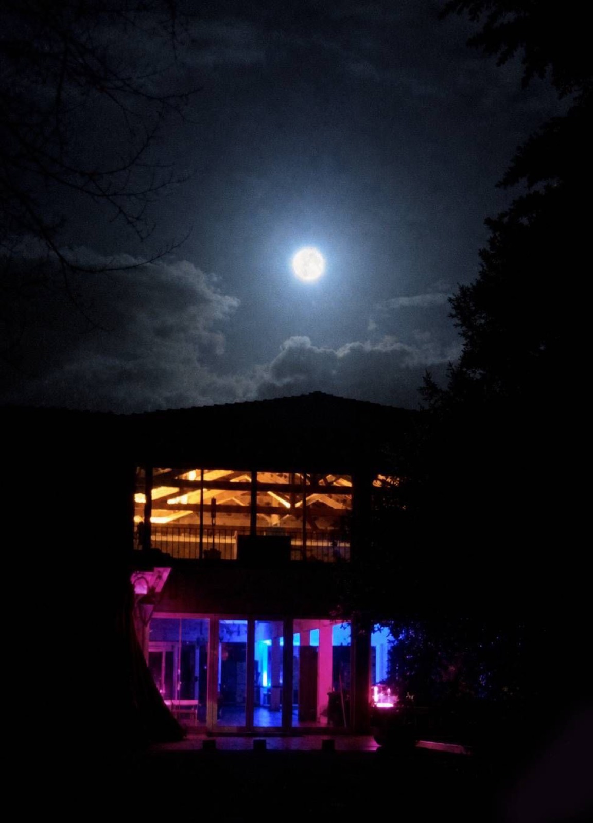 the dance hall lit up at night under a full moon